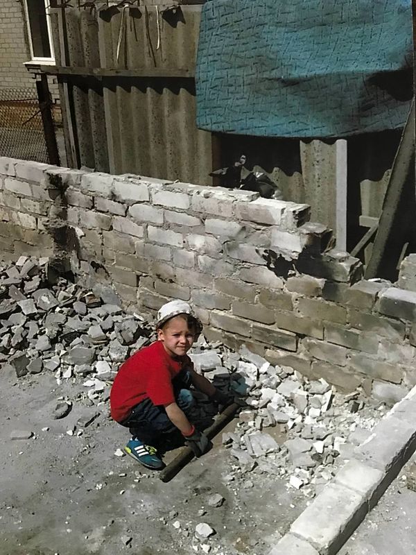 Młodszy wnuk Giennadija i Iriny pomaga dziadkom w ruinach domu (fot. arch. rodzinne)