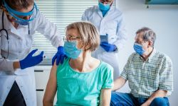 medical team giving coronavirus vaccine to seniors in vaccination center