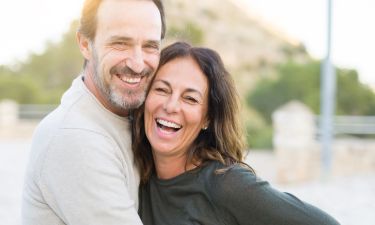 Romantic,Couple,Smiling,And,Cuddling,On,A,Sunny,Day