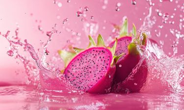 Creative layout made from Dragonfruit or Pitaya and Water splashing on a pink background