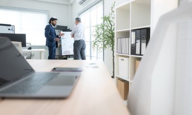In a contemporary office, two senior executives with a mission to brainstorm and monitor the progress of a business project