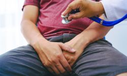 A man suffering from urinary tract infections visits a doctor at the examination table in a hospital.symptoms, discusses benign prostatic hyperplasia (BPH), and provides advice and treatment