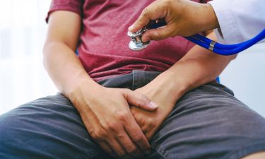 A man suffering from urinary tract infections visits a doctor at the examination table in a hospital.symptoms, discusses benign prostatic hyperplasia (BPH), and provides advice and treatment