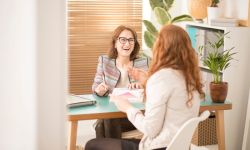 Smiling corporate advisor supporting a burnt out employee in the office